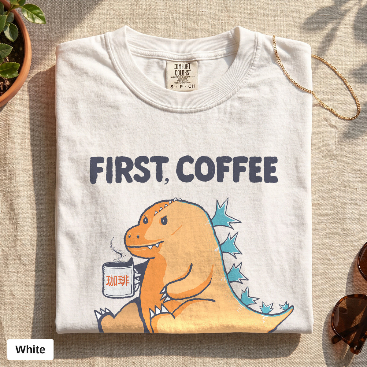 First Coffee dinosaur graphic tee, Comfort Colors 1717 in White, folded flat lay