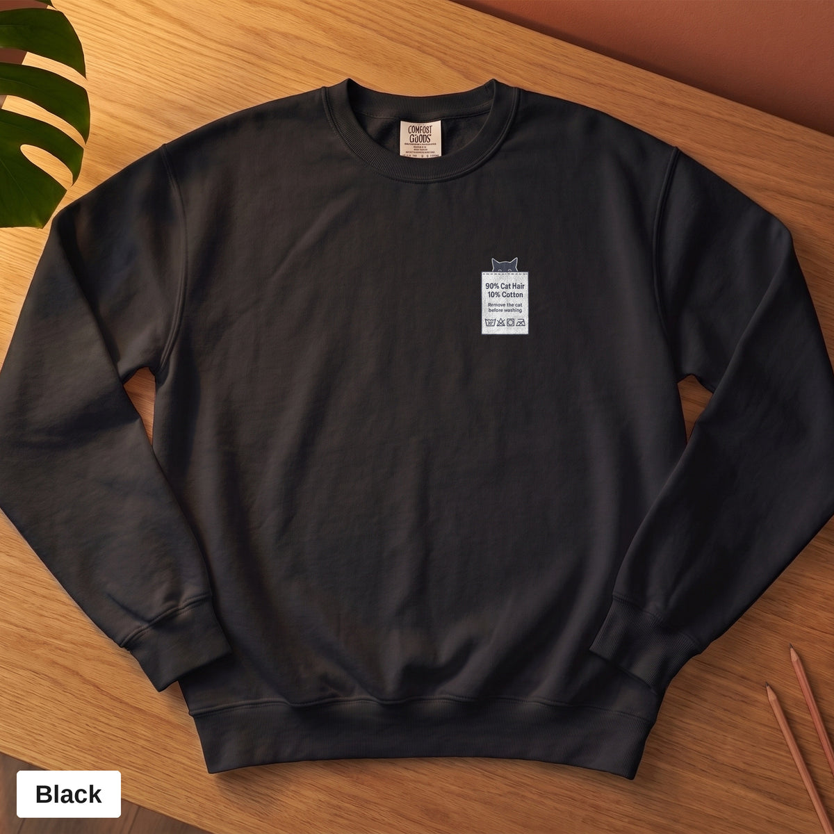 Black Comfort Colors crewneck sweatshirt, folded flat lay, 90% Cat Hair 10% Cotton design printed on the chest