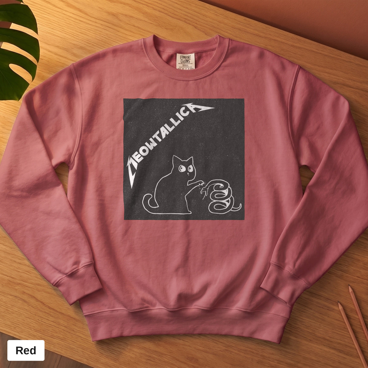 Crimson Comfort Colors crewneck sweatshirt, folded flat lay, metal cat and snake design printed on the chest