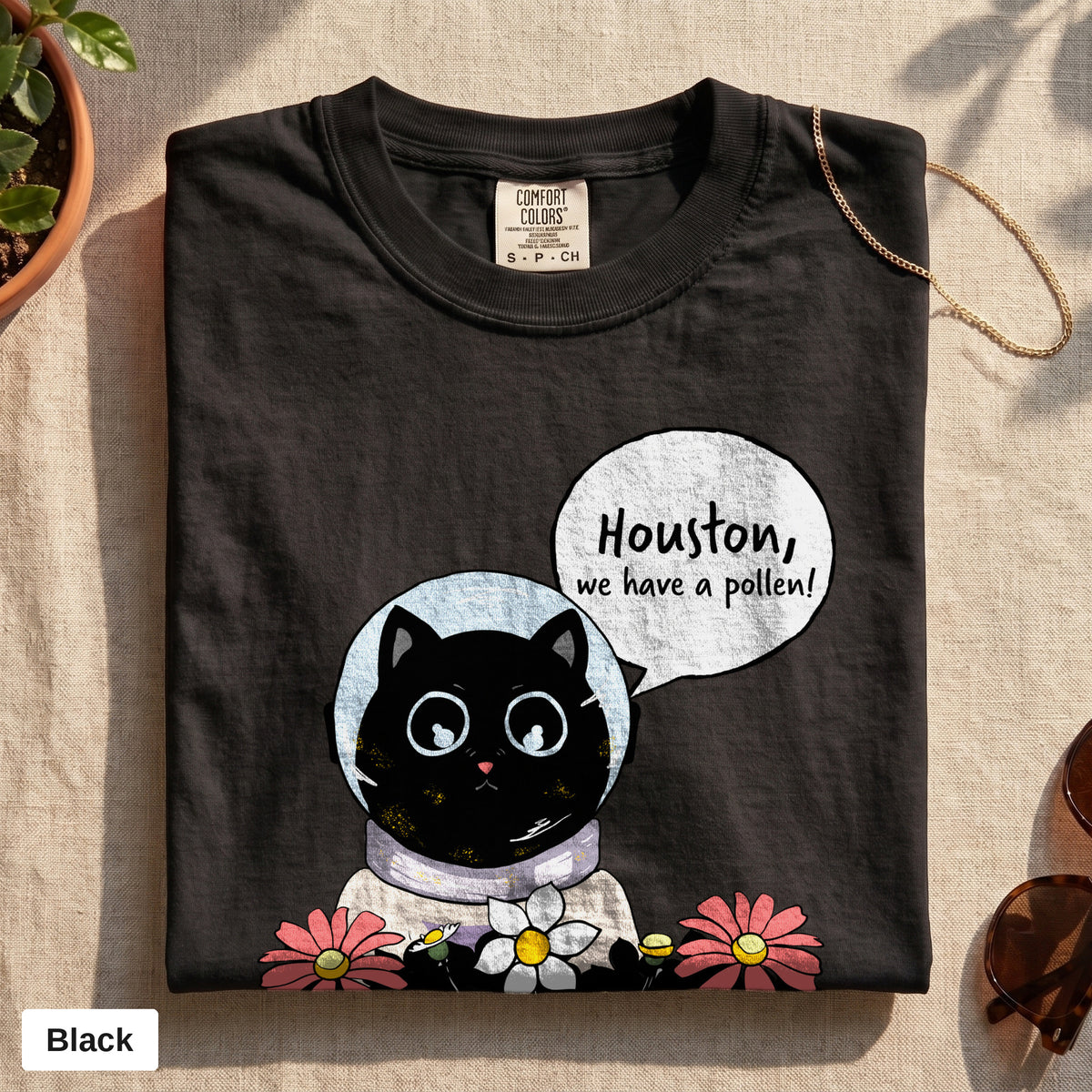 Houston We Have A Pollen cat astronaut tee, Comfort Colors 1717 in Black, folded flat lay
