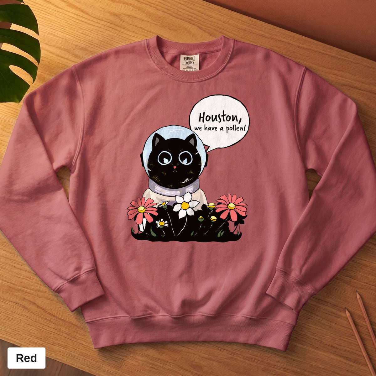 Crimson Comfort Colors crewneck sweatshirt, folded flat lay, Houston We Have A Pollen cat astronaut design printed on the chest