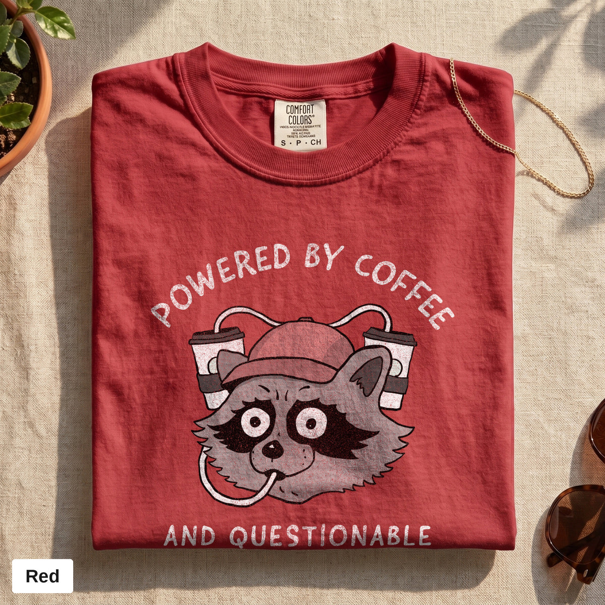 Powered By Coffee And Questionable Life Choices raccoon tee, Comfort Colors 1717 in Red, folded flat lay