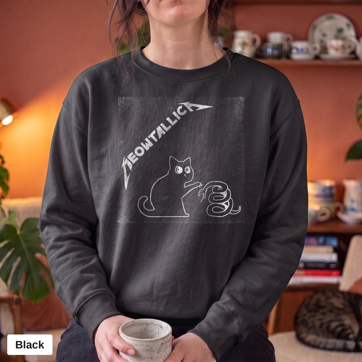 Black Comfort Colors crewneck sweatshirt worn by a model, metal cat and snake design printed on the chest