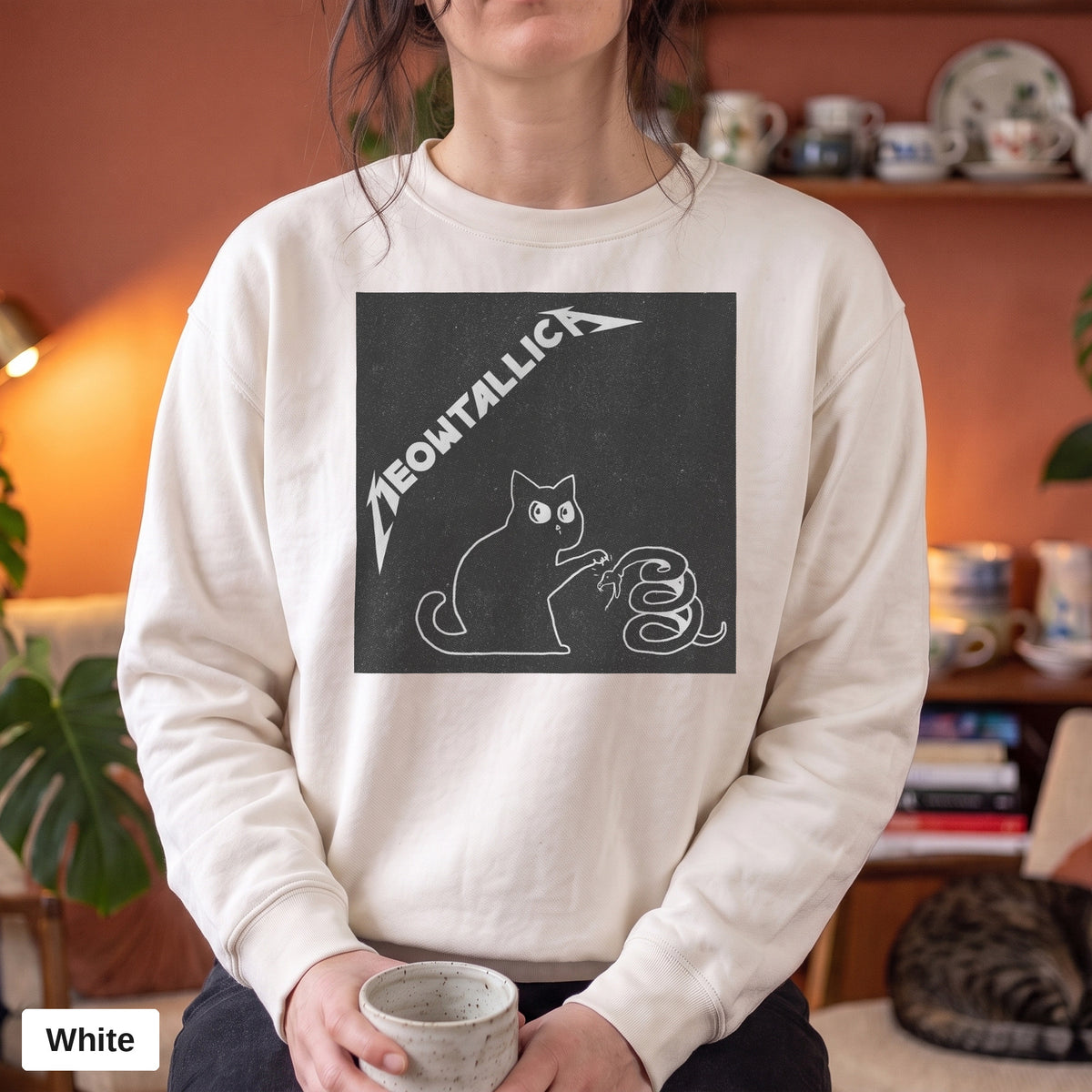 White Comfort Colors crewneck sweatshirt worn by a model, metal cat and snake design printed on the chest