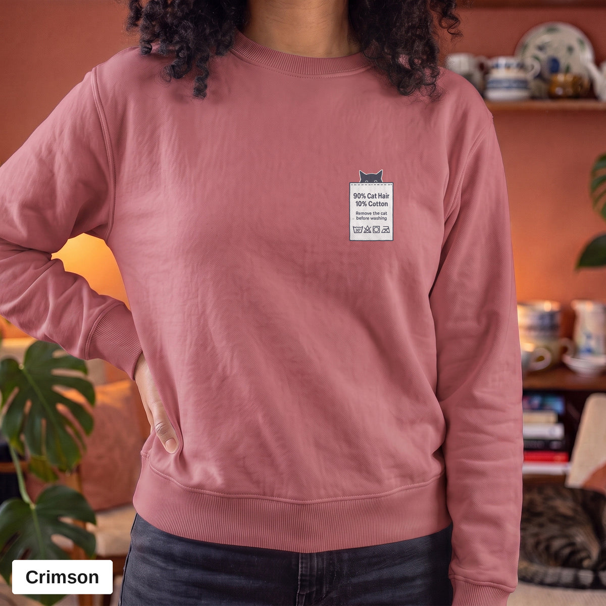 Crimson Comfort Colors crewneck sweatshirt worn by a model, 90% Cat Hair 10% Cotton design printed on the chest