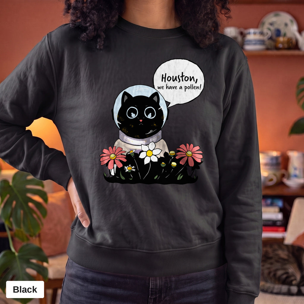 Black Comfort Colors crewneck sweatshirt worn by a model, Houston We Have A Pollen cat astronaut design printed on the chest